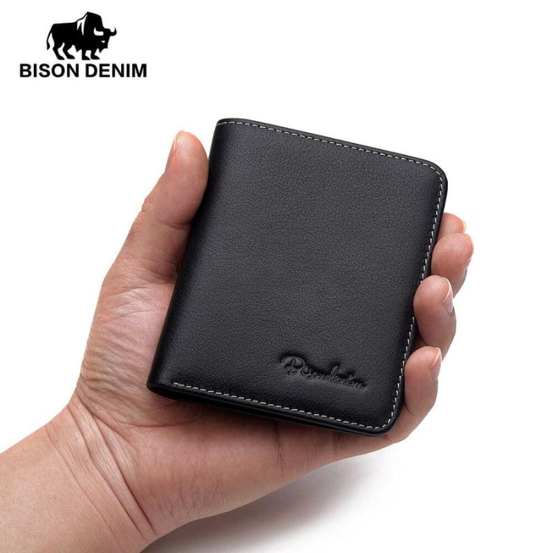 Carteira masculina Bison Denim preta em couro sendo segurada na mão